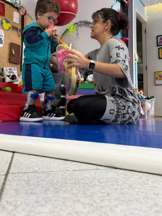 Dafne entregando um brinquedo a uma criança em sessão de atendimento